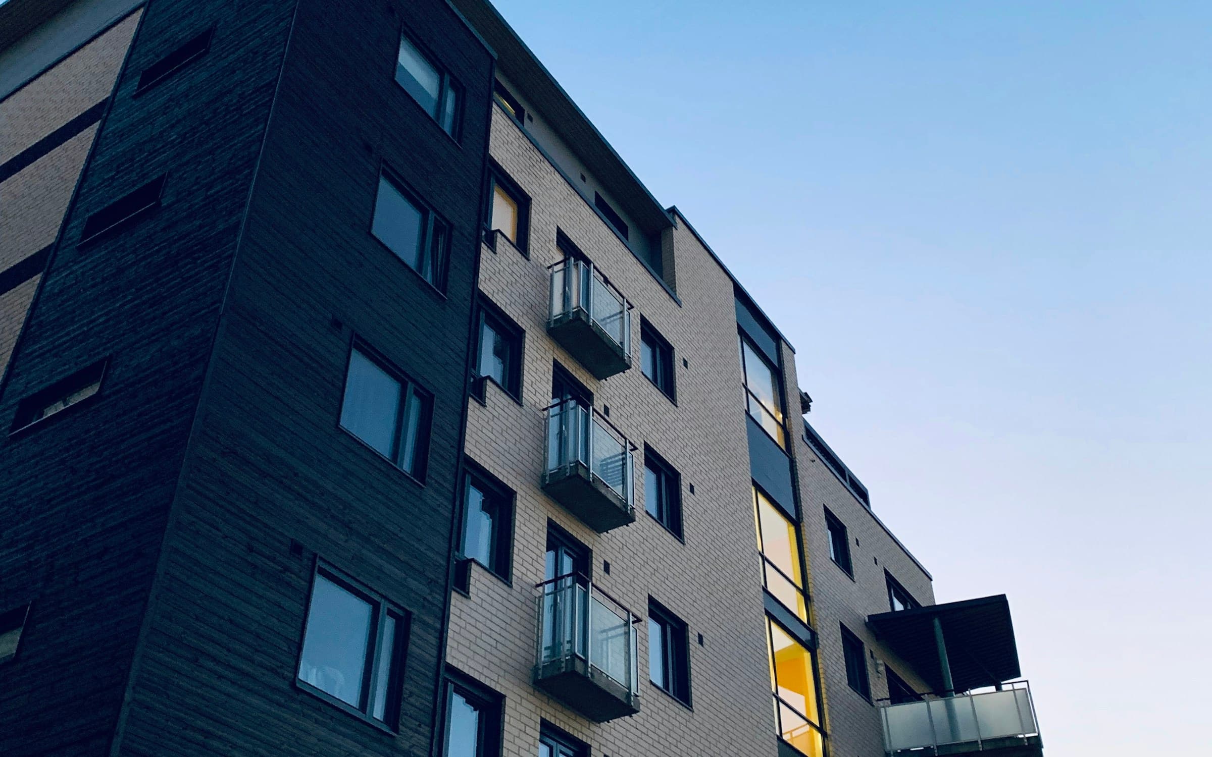 Modern apartment building with suites and balconies under a clear blue sky